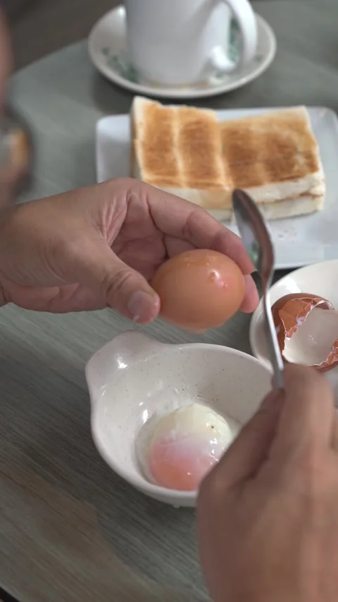 Cracking open a half boiled egg. Stock Footage 206939563