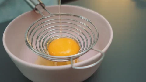 Cracking a raw egg into an egg separator Видео 252205240