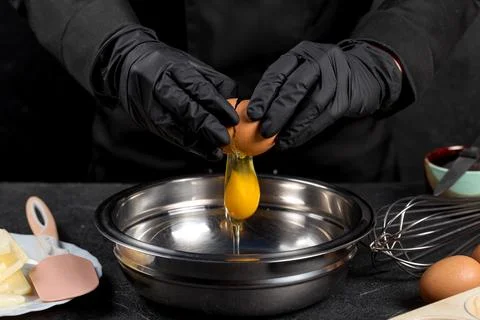 Cracking raw eggs into a bowl for making a cake 스톡 사진