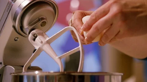 Cracking two eggs and putting them into a stand mixer Stock Footage 111677845