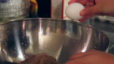 Cracking two eggs into a bowl with a brownie mix Stock Footage 65798325