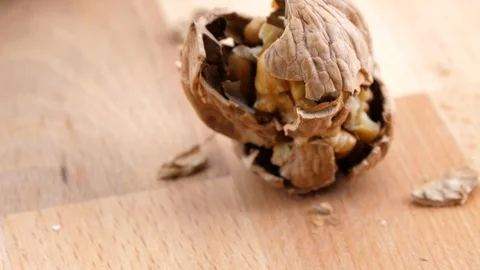 Cracking walnut on wood background closeup Stock Footage 85957000