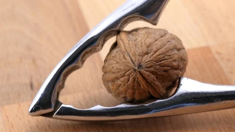 Cracking walnut on wood background closeup Stock Footage 85957237