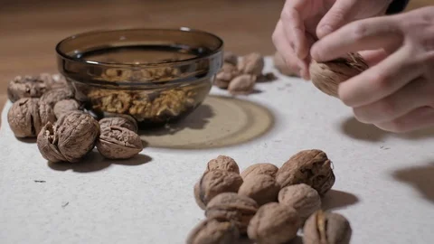 Cracking a walnuts at home. Hammer to break nuts. Collects a nuts in glass bowl Stock Footage 129085522