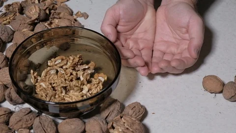 Cracking a walnuts at home. Hammer to break nuts. Collects a nuts in glass bowl Stock Footage 129086162