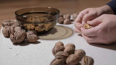 Cracking a walnuts at home. Hammer to break nuts. Collects a nuts in glass bowl Stock Footage 129086179