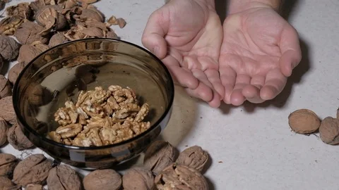 Cracking a walnuts at home. Hammer to break nuts. Collects a nuts in glass bowl Stock Footage 129086189