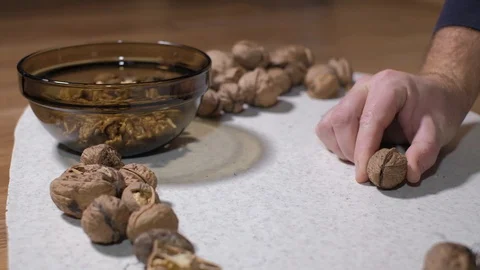 Cracking a walnuts at home. Hammer to break nuts. Collects a nuts in glass bowl Stock Footage 129086190