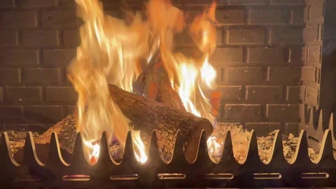 Crackling Fireplace Flames on Brick Wall with Metal Grate and Logs Video stock 325491710