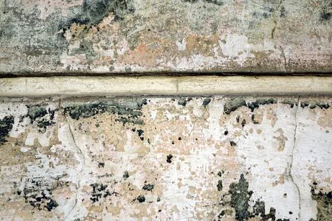 Cracks and destroyed paint on the cement wall finish. Spots of white, shade.. Stock Photos