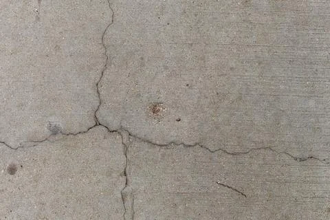 Cracks and texture on a concrete surface with small debris scattered throug.. Stock Photos