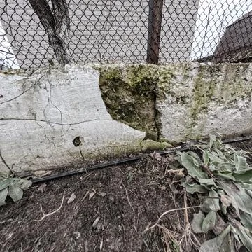Cracks in the foundation. destroyed foundation. Effect of an old tuff wall .. Stock Photos