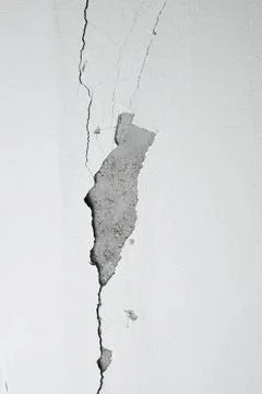 Cracks on the gray wall. Cement background. The concept of unfinished repairs. Foto stock