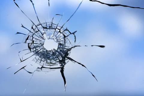 Cracks in the window glass on a background of sky. Stock Photos