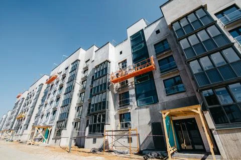 Cradle with builders at the construction site of multi-apartment modern houses Stock Photos