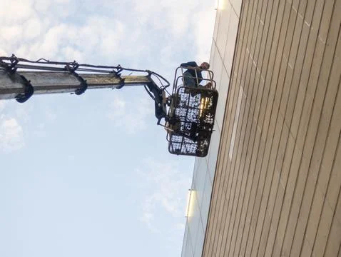 Cradle with the worker is at height. Working on a crane. dressmaker in acti.. Stock Photos