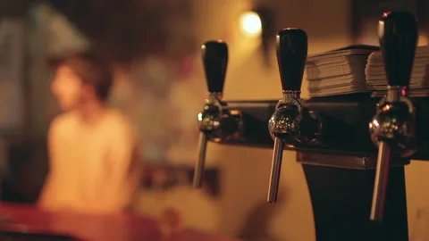 Craft Beer Taps Close Up with Blurred Patron at Bar Counter Stock Footage 346236443