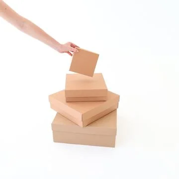 Craft boxes of different sizes with a hand on a white background. Place for.. Stock Photos