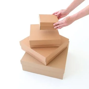 Craft boxes of different sizes with a hand on a white background. Place for.. Stock Photos