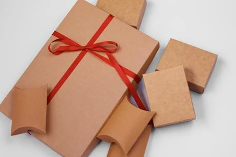 Craft boxes. A large gift box tied with a red ribbon. Lots of little boxes ar Stock Photos