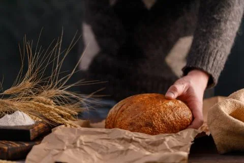 Craft bread closeup in man's hand. The concept of healthy food and traditiona Stock Photos