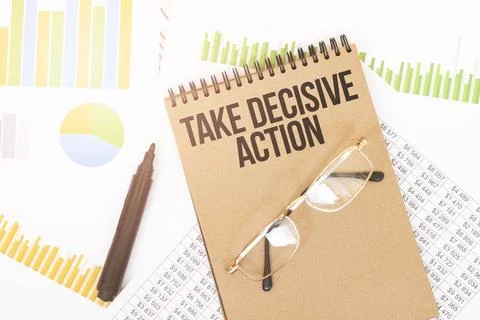 In a craft colour notebook is a TAKE DECISIVE ACTION inscription, next to pen Foto stock