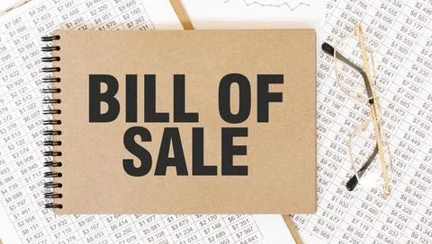 Craft colour notepad with text BILL OF SALE. Notepad with eyeglasses and te.. Stock Photos