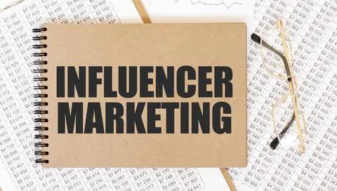 Craft colour notepad with text INFLUENCER MARKETING. Notepad with eyeglasse.. Stock Photos