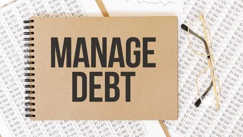 Craft colour notepad with text Manage Debt. Notepad with eyeglasses and text  Stock Photos
