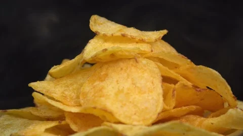 Craft crispy hot potato chips with smoke rotating on black background close up. Stock Footage 196697798