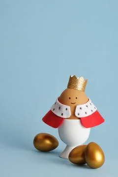 A craft Easter egg of a king with a crown and red robe on a blue background.  Stock Photos