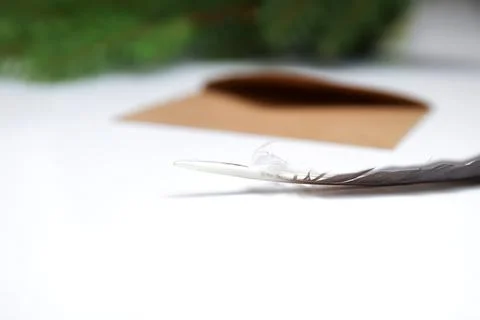 Craft eco envelope, close-up feather pen on white background. Christmas holid Stock Photos
