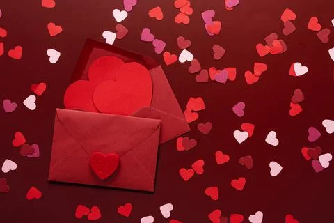Craft envelope with a blank sheet of paper inside and red heart on the red ba Stock Photos