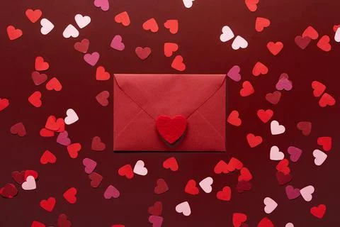 Craft envelope with a blank sheet of paper inside and red heart on the red ba Stock Photos