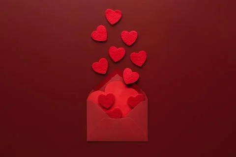 Craft envelope with a blank sheet of paper inside and red heart on the red ba Stock Photos