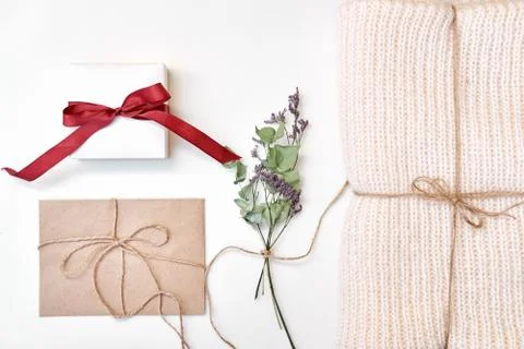 Craft envelope, gift box with bow, knitted scarf, dried flowers and leaves on Stock Photos