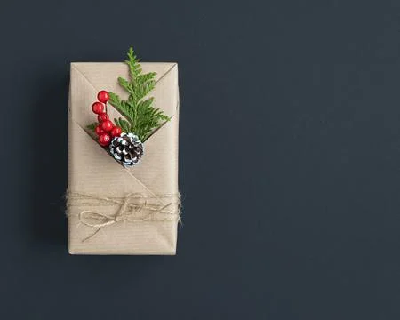 Craft gift box with pine and berries on a dark background. Copyspace. 스톡 사진