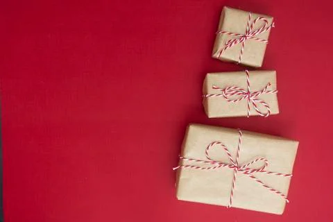 Craft gift boxes over red background. Christmas mockup with copy space. winte Stock-Fotos