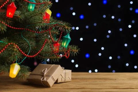 Craft gifts under the tree, on the table, against the background of blurry li Stock Photos