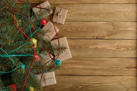 Craft gifts under the tree, on the table, against the wood background. The co Stock Photos