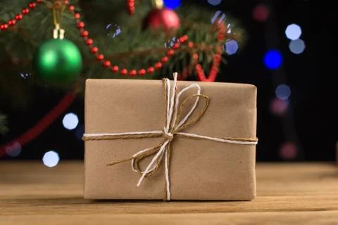 Craft gifts under the tree, on the table, against the background of blurry li Stock Photos