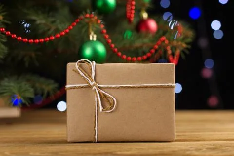 Craft gifts under the tree, on the table, against the background of blurry li Stock Photos