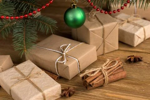 Craft gifts under the tree, on the table, against the wood background. The co Stock Photos