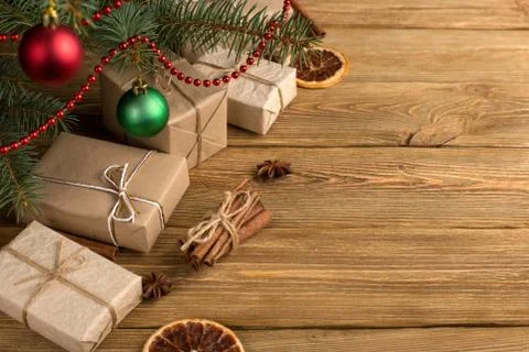 Craft gifts under the tree, on the table, against the wood background. The co Stock Photos