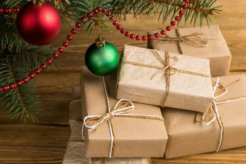 Craft gifts under the tree, on the table, against the wood background. The co Stock Photos