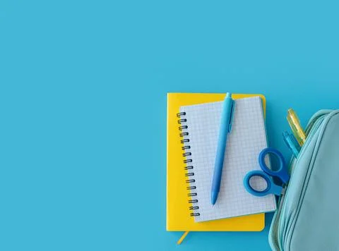 Craft kit with yellow notebook blue pen and pencil case on blue background,.. Stock Photos