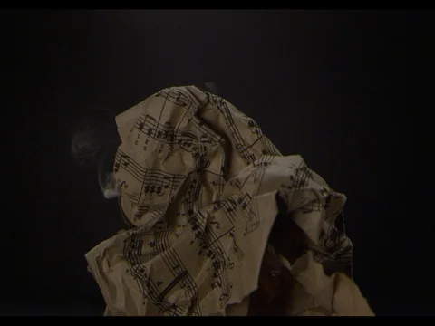 Craft music paper burning on a black background, close-up, Ignition of fire Stock Footage