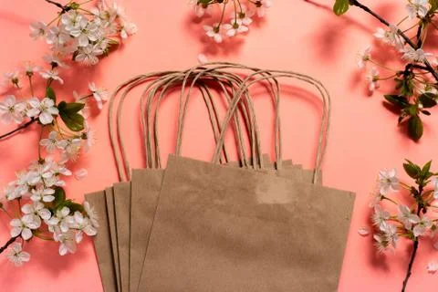 Craft packages on a pink background in a frame of cherry flowers. Фото