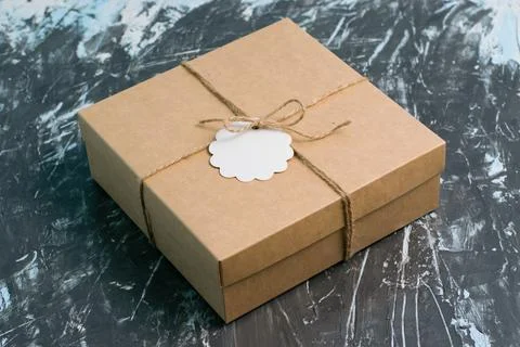 Craft packaging with a gift, on a dark background. Concept for Christmas and  Stock Photos