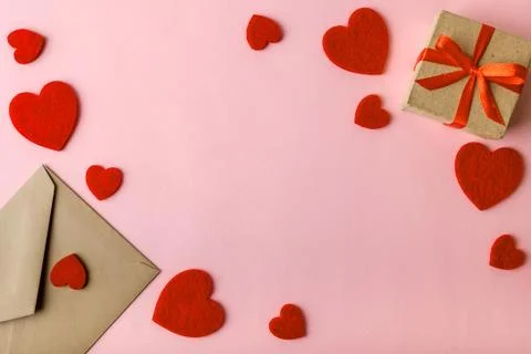 Craft paper envelope, gift box with red ribbon and valentine hearts on a pink Stock Photos
